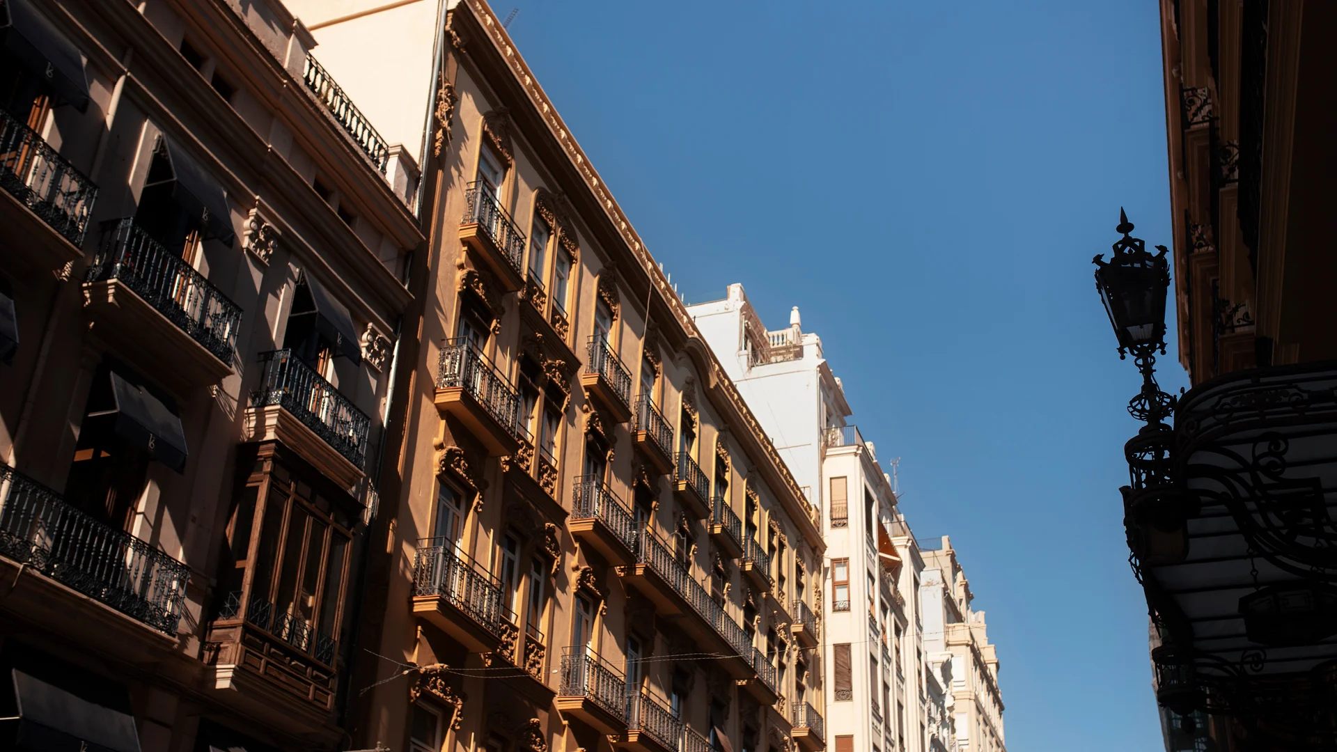 Street view of traditional residential buildings in Spain, illustrating the granular market for real estate investment.